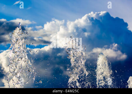 Fontana gocce di pura acqua brillante contro le nubi Foto Stock