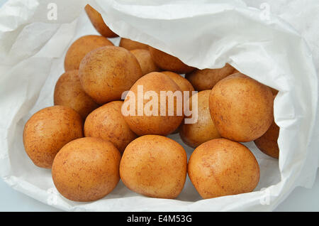 Patate di marzapane in un libro bianco borsa, vicino, isolati su sfondo bianco, full frame Foto Stock