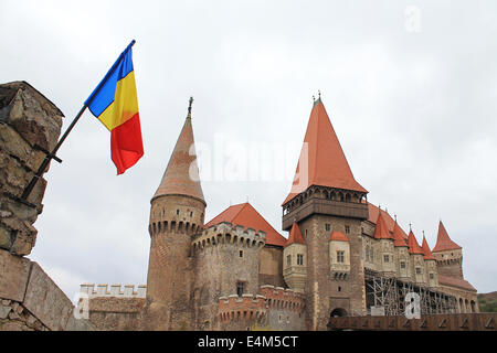 Il Hunyad o Corvin castello di Hunedoara, Transilvania, Romania con la bandiera rumena Foto Stock