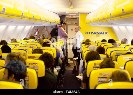 I passeggeri in una coda per il gabinetto durante un volo aereo Ryanair interni cabina Foto Stock