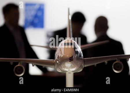 Gli acquirenti anonimi discutere le trattative dietro il modello di un Boeing 747 aereo jet al salone di Farnborough, Inghilterra. Il Farnborough Airshow internazionale è un evento della durata di una settimana che unisce un grande salone per i settori aerospaziale e della difesa con un airshow di pubblico. Secondo gli organizzatori, la 2012 Farnborough Visualizza attratto 109.000 visitatori professionali per i primi cinque giorni e 100.000 visitatori il sabato e la domenica. Ordini e impegni per 758 aerei sono stati annunciati, vale la pena di US$72 miliardi. Foto Stock