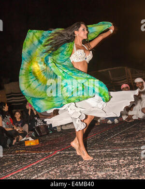 Una danzatrice del ventre ghirigori per gli ospiti a beduino desert safari camp fuori Dubai, Emirati arabi uniti Foto Stock