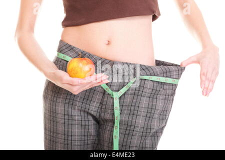 La donna che mostra quanto peso ha perso apple. Uno stile di vita sano concetto isolato Foto Stock