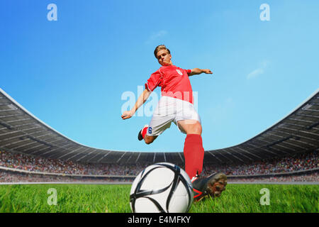 Giocatore di calcio calciare la palla Foto Stock