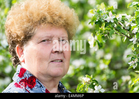 Donna anziana in un giardino di primavera Foto Stock