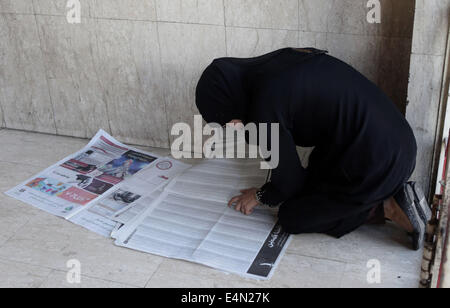 Ramallah, West Bank, Territorio palestinese. Il 15 luglio 2014. Un palestinese di alta scuola studente legge un giornale locale per trovare i risultati della sua ricerca in Cisgiordania città di Ramallah il 24 luglio 2011. Foto Stock