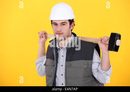 Un uomo che porta una mazza. Foto Stock