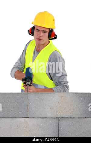 Builder utilizzando un trapano per muratura Foto Stock