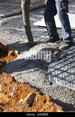 Workman la colata di cemento sul sito di costruzione Foto Stock