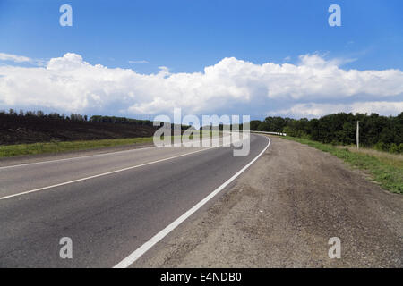 Strada vuoto circondato da campi Foto Stock