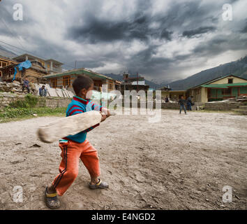 Indian i bambini a giocare a cricket in un villaggio Foto Stock