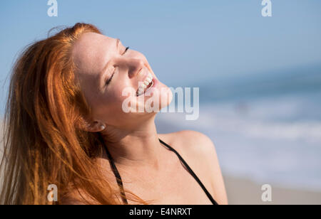 Donna sulla spiaggia suntanning Foto Stock