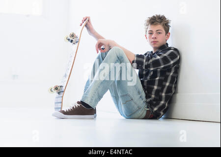 Ragazzo adolescente (16-17) azienda skateboard Foto Stock