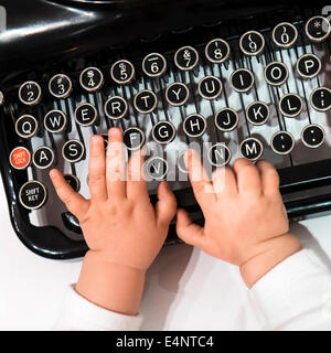 Studio shot dei neonati (6-11 mesi) mano toccando i nastri inchiostratori per macchine da scrivere Foto Stock