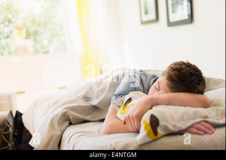 Ragazzo adolescente (16-17) dormire nel letto Foto Stock