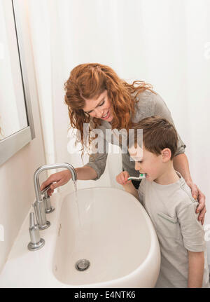 Figlio (6-7) e la madre la spazzolatura dei denti Foto Stock