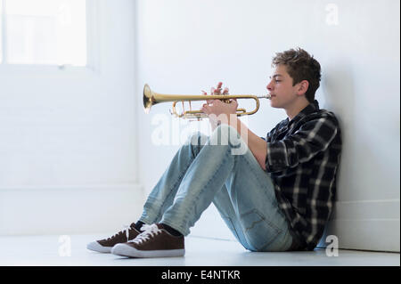 Ragazzo adolescente (16-17) suonare la tromba in corridoio Foto Stock