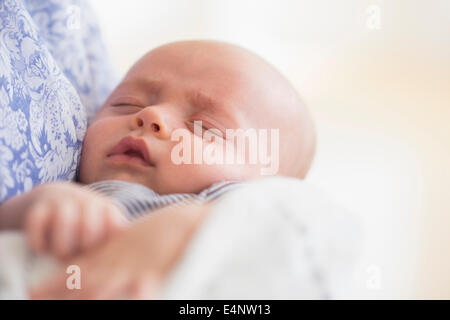 Close up baby boy (2-5 mesi) dormire nella madre di braccia Foto Stock