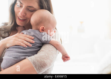 Azienda madre baby boy (2-5 mesi) sul suo braccio Foto Stock