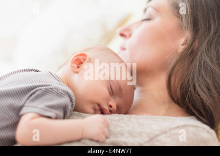 Madre con bambino (2-5 mesi) tenendo il nap insieme Foto Stock