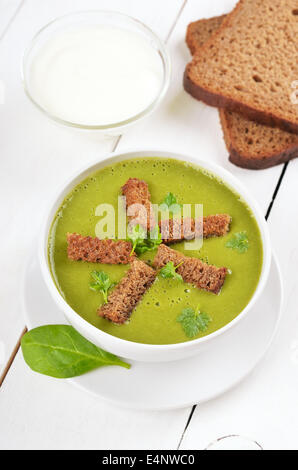 Zuppa di spinaci con secchi di croste sul tavolo di legno Foto Stock