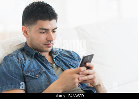 Giovane uomo utilizzando il telefono cellulare Foto Stock