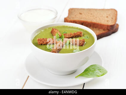 Zuppa di spinaci con secchi di croste sul tavolo di legno Foto Stock