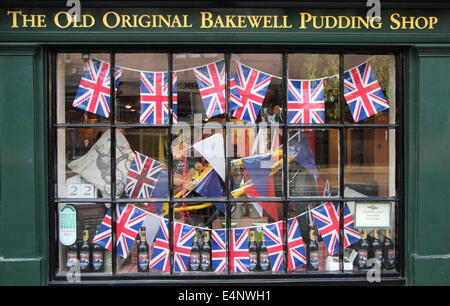 Unione Jack bunting visualizzato nella finestra della vecchia originale Bakewell Pudding Shop, Bakewell, Peak District, England, Regno Unito Foto Stock