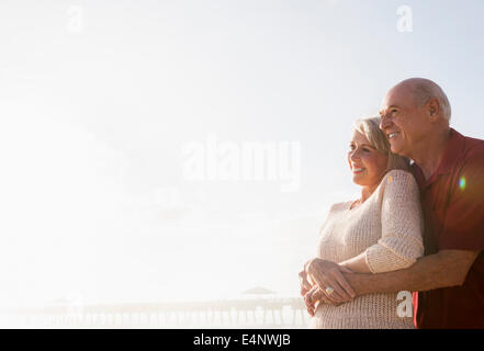 Coppia senior abbracciando sulla spiaggia Foto Stock