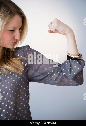 Ritratto di donna bionda che mostra il muscolo Foto Stock