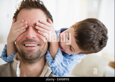 Figlio (8-9) copertura padre agli occhi Foto Stock