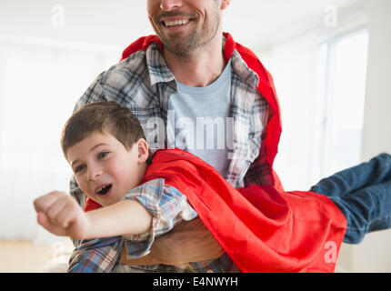 Padre e figlio (8-9) che agisce come super eroi Foto Stock