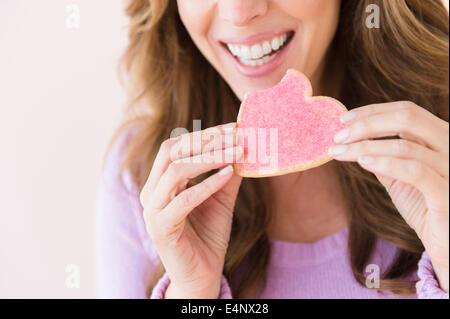 Donna che mantiene la forma di cuore cookie Foto Stock