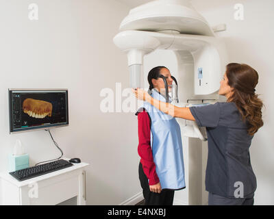 Assistant rendendo immagine a raggi x dei denti del paziente Foto Stock