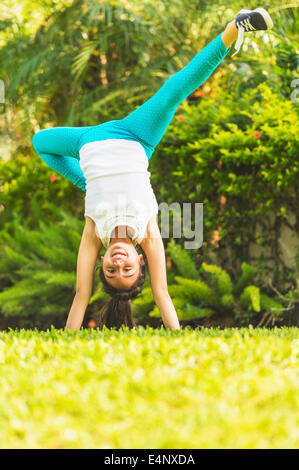 La ragazza (8-9) facendo appoggiate sul cortile anteriore Foto Stock