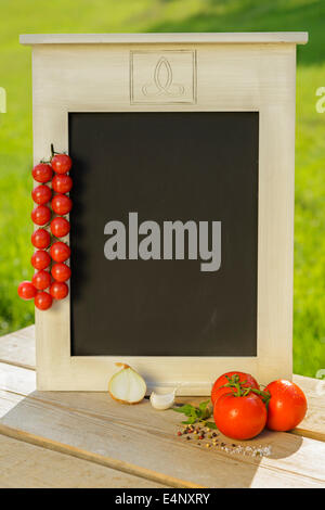 Cipolla pomodoro aglio basilico spezie le erbe aromatiche fresche sale pepe tavolo in legno lavagna verde rosso fuori sana nutrizione outdoor Foto Stock