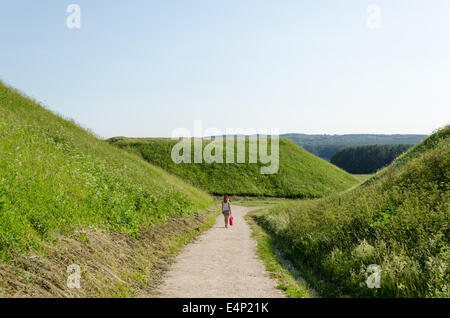 Ragazza turistiche a piedi tra mound hills in lituano capitale storica Kernave, Sito Patrimonio Mondiale dell'UNESCO. Foto Stock