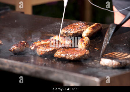 La carne che viene controllato con un termometro a sonda Foto Stock