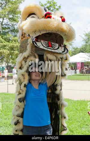 Donna mettendo su Lion costume al cinese festival - USA Foto Stock