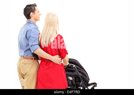 I giovani genitori spingere un passeggino isolata contro uno sfondo bianco, vista posteriore Foto Stock