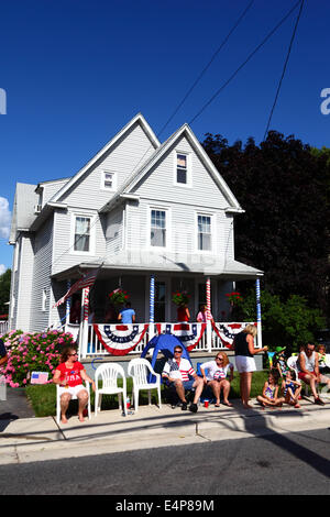 Gli spettatori seduti fuori decorato portico di casa godendo il 4 luglio il Giorno di Indipendenza parate, Catonsville, Maryland, Stati Uniti d'America Foto Stock