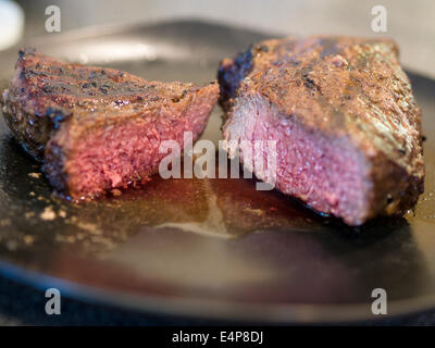 Bistecca di cervo tagliata. Un cotto Bistecca di cervo tagliata in due pezzi per rivelare i suoi interni di colore rosa. Ottawa, Ontario, Canada Foto Stock