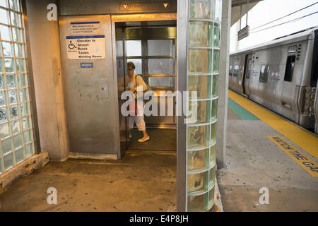 Merrick, New York, Stati Uniti d'America. 14 Luglio, 2014. In serata durante le ore di punta, una donna passeggero da un treno entra in ascensore sulla piattaforma sopraelevata di andare giù al livello della strada di Merrick stazione ferroviaria di Babilonia il ramo, dopo MTA Metropolitan Transit Authority e Long Island Rail Road unione parla deadlock, con potenziale sciopero LIRR aleggiano pochi giorni prima. © Ann Parry/ZUMA filo/Alamy Live News Foto Stock