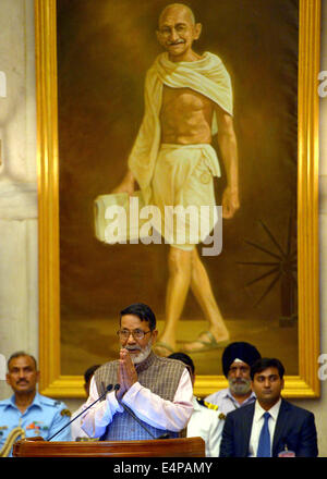 New Delhi. 16 Luglio, 2014. Chandi ambientalista Prasad Bhatt (anteriore) i gesti di fronte ad una dimensione di vita ritratto del Mahatma Gandhi dopo il Presidente indiano Pranab Mukherjee lo presenta Gandhi Peace Prize 2013 nel palazzo presidenziale di New Delhi, India, 15 luglio, 2014. Il Gandhi Peace Prize è stato istituito dal governo indiano nel 1995 in occasione del centoventicinquesimo anniversario della nascita del Mahatma Gandhi. © Xinhua/Alamy Live News Foto Stock