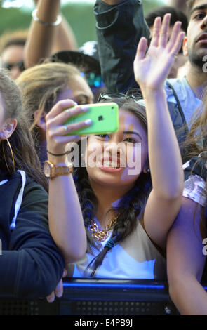 Una giovane donna guardando bande a un OUTDOOR festival di musica e di introito su telefono cellulare ri festival rock cantanti adolescenti REGNO UNITO Foto Stock