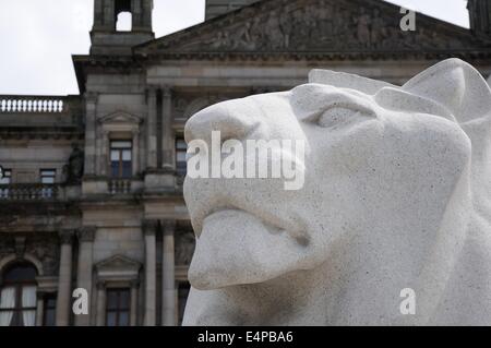 Leone di pietra statua al di fuori della città camere in Glasgow's George Square, Scotland, Regno Unito Foto Stock