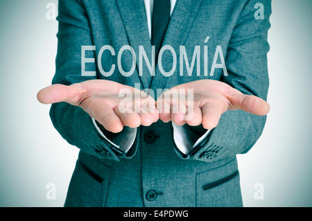 Un imprenditore con la parola economia, economia in spagnolo, nelle sue mani Foto Stock