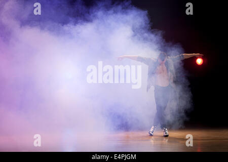 Giovani e uomo muscolare eseguendo una danza contemporanea pone su di un palco. Foto Stock