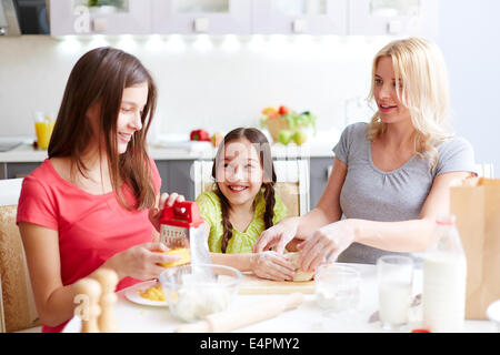 Ritratto di felice femmine rendendo l'impasto e preparazione di ingredienti per pizza Foto Stock