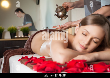 Donna godendo di Ayurveda massaggio con olio a spa Foto Stock